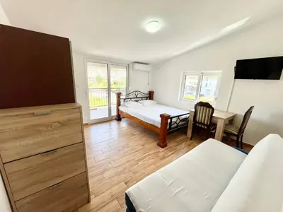 a living room with a bed and a dining room at B&V apartmani in Bar, Susanj