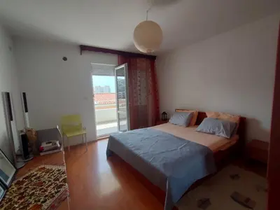 a bedroom with a bed and a large window at MiNa Apartments in Petrovac na Moru