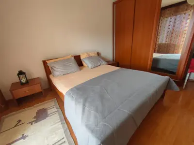 a bedroom with a large bed and a mirror at MiNa Apartments in Petrovac na Moru