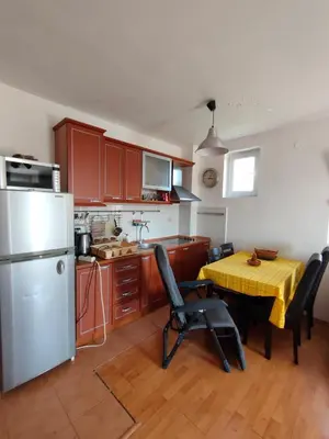a kitchen with a table with chairs and a refrigerator at MiNa Apartments in Petrovac na Moru