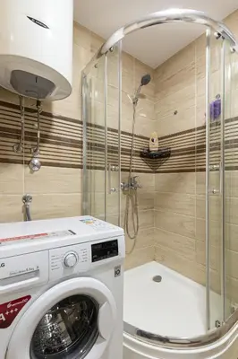 a washing machine in a bathroom with a shower at Budva Olive Escape in Budva
