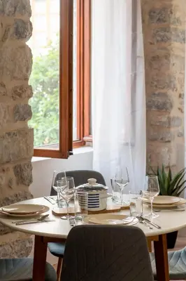 a table with glasses and plates and a window at Modern Design Old Town Apartment by MN Property in Kotor