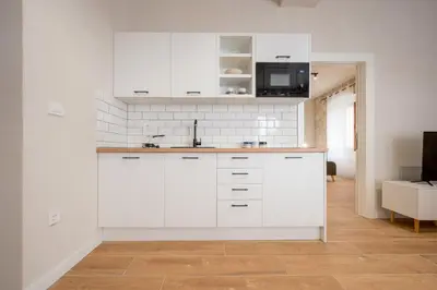 a white kitchen with white cabinets and a microwave at Modern Design Old Town Apartment by MN Property in Kotor