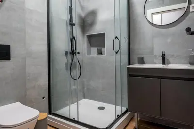 a bathroom with a shower and a toilet and a sink at Modern Design Old Town Apartment by MN Property in Kotor