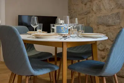 a table with chairs and wine glasses on it at Modern Design Old Town Apartment by MN Property in Kotor