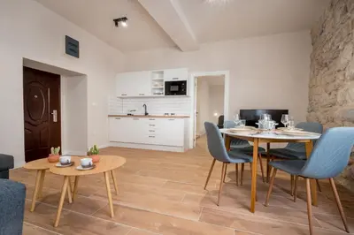 a living room with a table and chairs and a kitchen at Modern Design Old Town Apartment by MN Property in Kotor
