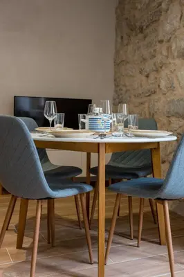 a wooden table with chairs and wine glasses on it at Modern Design Old Town Apartment by MN Property in Kotor