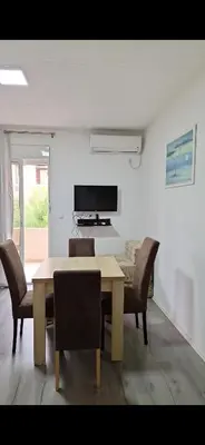 a dining room with a table and chairs at Apartmani Madžgalj Sutomore in Sutomore