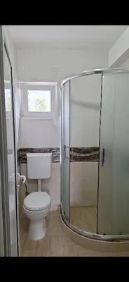 a bathroom with a toilet and a glass shower at Apartmani Madžgalj Sutomore in Sutomore