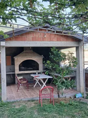 a patio with a table and a pizza oven at Apartmani Madžgalj Sutomore in Sutomore