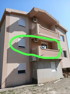 a building with a green circle on the side of it at Apartmani Madžgalj Sutomore in Sutomore
