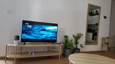 a flat screen tv on a wooden stand in a living room at BrandNew Apartment in Podgorica