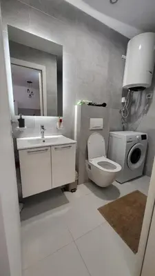 a bathroom with a toilet and a sink and a mirror at BrandNew Apartment in Podgorica