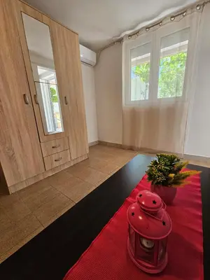 a living room with a door and a red rug at Vila Lučica apartman u prizemlju in Petrovac na Moru