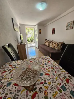a living room with a table and a couch at Vila Lučica apartman u prizemlju in Petrovac na Moru