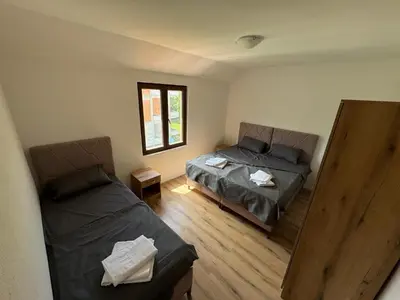 a bedroom with a bed and a couch at Apartments Tripoint Kotor in Kotor