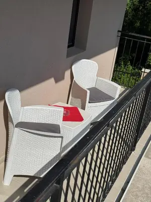 two white chairs sitting on top of a balcony at Apartments Tripoint Kotor in Kotor