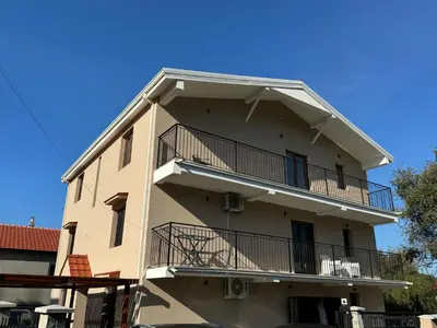 an apartment building with balconies and a blue sky at Apartments Tripoint Kotor in Kotor