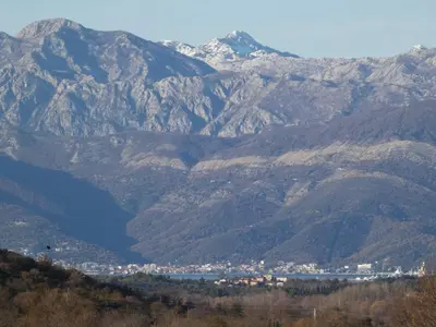a view of a mountain range with a city and a lake at Apartments Tripoint Kotor in Kotor