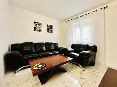 a living room with a black leather couch and a coffee table at MorePlanina in Sutomore