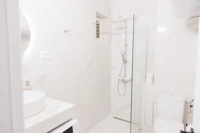 a white bathroom with a shower and a sink at Home of Sveti Stefan in Sveti Stefan