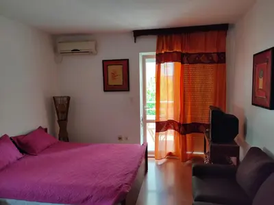a bedroom with a purple bed and a window at MiNa Studio Petrovac in Petrovac na Moru