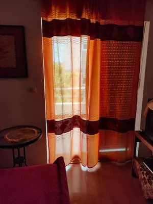 a window with a curtain in a living room at MiNa Studio Petrovac in Petrovac na Moru