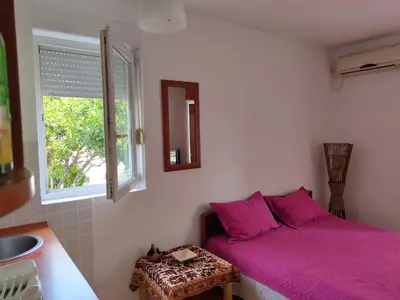 a bedroom with a purple bed and a window at MiNa Studio Petrovac in Petrovac na Moru