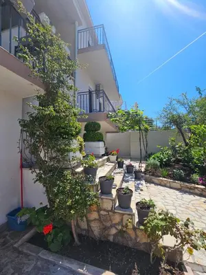 a courtyard with potted plants and a building at Vila Lučica apartman 2 pogled planina in Petrovac na Moru
