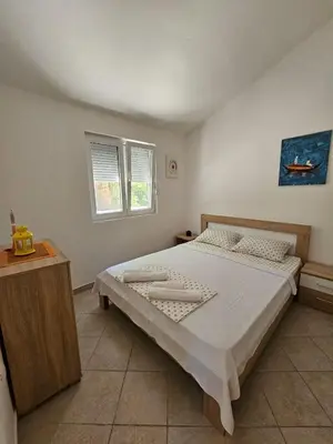 a bedroom with a large bed in a room at Vila Lučica apartman 2 pogled planina in Petrovac na Moru