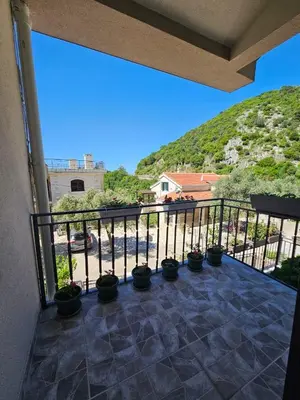 a balcony with potted plants and a hill at Vila Lučica apartman 2 pogled planina in Petrovac na Moru