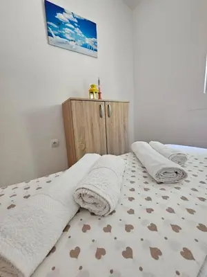 a bedroom with two white towels on a bed at Vila Lučica apartman 2 pogled planina in Petrovac na Moru