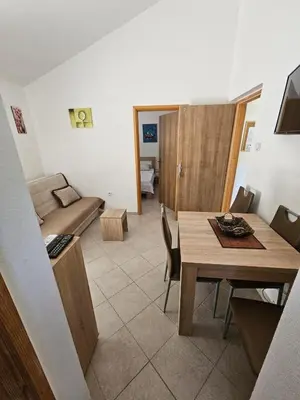 a living room with a table and a couch at Vila Lučica apartman 2 pogled planina in Petrovac na Moru