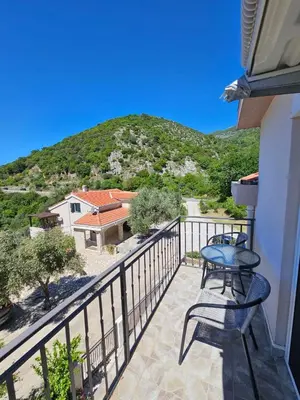a balcony with a table and chairs and a mountain at Vila Lučica studio pogled na more in Petrovac na Moru