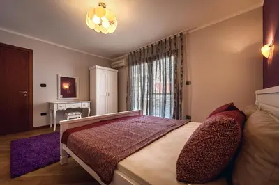 a bedroom with a large bed and a window at Luxury Apartments Rafailovichi 1 st of the sea line in Rafailovici