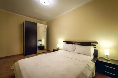 a bedroom with a bed with two lamps and a mirror at Luxury Apartments Rafailovichi 1 st of the sea line in Rafailovici