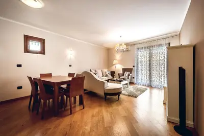 a dining room and living room with a table and chairs at Luxury Apartments Rafailovichi 1 st of the sea line in Rafailovici