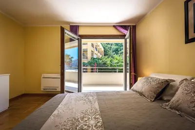 a bedroom with a bed and a large window at Luxury Apartments Rafailovichi 1 st of the sea line in Rafailovici