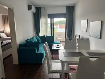 a living room with a blue couch and a table at Apartman Sofija in Ulcinj