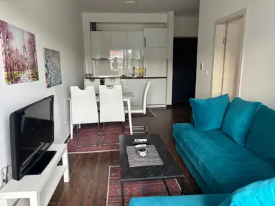 a living room with a blue couch and a table at Apartman Sofija in Ulcinj