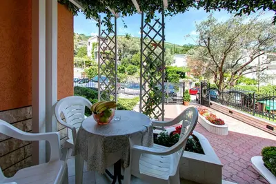 a table and chairs on a porch with a view of a patio at Vila Koral in Petrovac na Moru