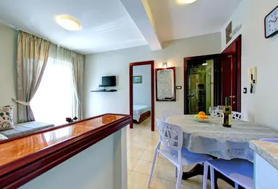 a dining room with a table and a living room at Vila Koral in Petrovac na Moru