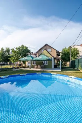 a swimming pool in front of a house at Nika house in Cetinje