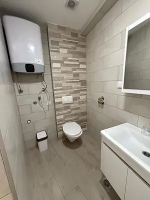 a white bathroom with a toilet and a sink at Morski kutak in Sutomore