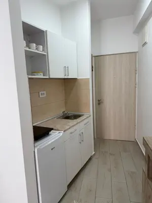 a small kitchen with white cabinets and a sink at Morski kutak in Sutomore