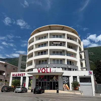 a tall white building with a voul sign on it at Morski kutak in Sutomore