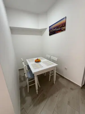 a white table and chairs with a bowl of fruit on it at Morski kutak in Sutomore