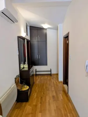 a living room with black cabinets and a wooden floor at Apartment Bjanka in Budva