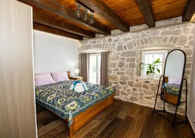 a bedroom with a bed and a stone wall at Apartmani Stone oasis in Zupci