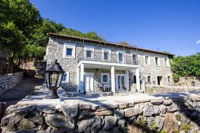 a stone house with a street light in front of it at Apartmani Stone oasis in Zupci